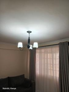 a chandelier in a living room with a window at Colokhaly Apartment in Nairobi