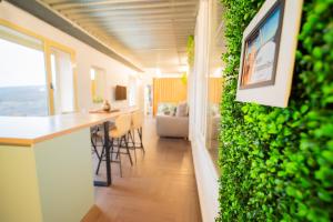 a living room with a green wall with a table and chairs at Mirador Torre de la Garrofa in Almería