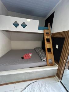a bunk bed with a ladder in a room at Loft fundos shopping Catuai e lago in Cascavel