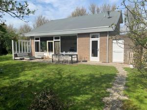 a brick house with a patio and a yard at de Brabander in Cadzand