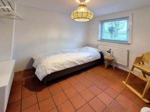a bedroom with a bed and a window and a chandelier at de Brabander in Cadzand