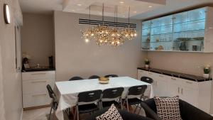une salle à manger avec une table et un lustre dans l'établissement Luxe on Dolev, à Bet Shemesh 8 autres photos