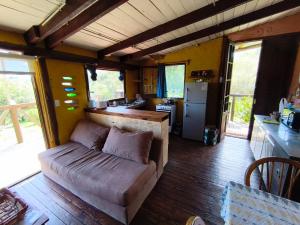 a living room with a couch and a kitchen at Odisea in Villa Serrana