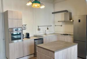 eine Küche mit weißen Schränken und Geräten aus Edelstahl in der Unterkunft Lemov'Inn, central historic apartment in Limoges