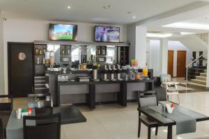 a restaurant with a bar with tables and chairs at Bella Vista Hotel - Encarnación in Encarnación