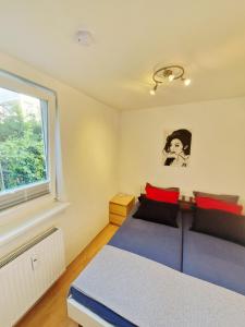 ヴィスマールにあるUrlaub im Herzen Wismars EG hinten mit Gartenの青いベッドと窓のある寝室