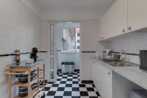 una cucina con pavimento a scacchi in bianco e nero di Funchal City Nest a Funchal