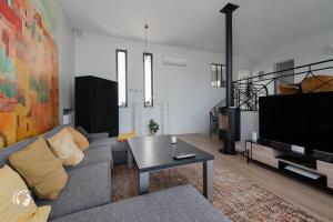 ベルリーヴ・シュル・アリエにあるVilla Solénaのソファとテレビのあるリビングルーム