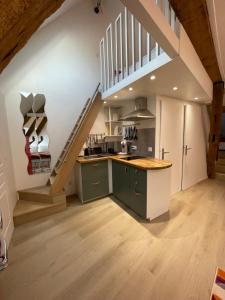 a kitchen with green cabinets and a staircase at Le loft insolite in Lormes