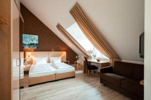 a bedroom with a bed and a desk and a couch at Weinhotel Wasem in Ingelheim am Rhein +61 photos