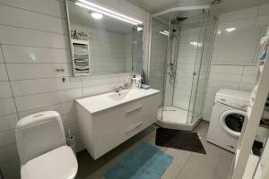 a bathroom with a sink and a washing machine at Spacious apartment with 4 bedrooms in Grimstad