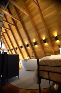 a bedroom with a tub in a wooden ceiling at Cabana Flor do Sol in Luzerna