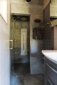 a bathroom with a shower with a glass door at Landgoed Boneman in Meddoo