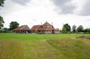 a large house in a field with a grass yard at Landgoed Boneman in Meddoo