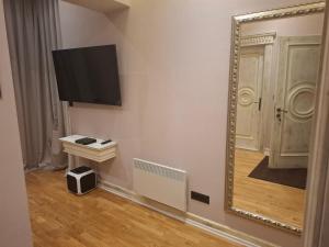 ベオグラードにあるStar Moda DOO Beograd Ogranak 1の壁掛けテレビ付きの部屋の鏡