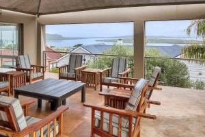 a patio with tables and chairs and a view of the water at Casa De Palmera Langebaan in Langebaan