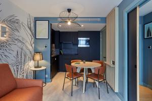 a dining room and kitchen with a table and chairs at Aparthotel Adagio London City East in London +23 photos