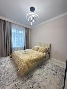 a bedroom with a bed and a large window at Двухкомнатная квартира с евроремонтом в центре Алматы, рядом с ТРЦ MEGA Center in Almaty