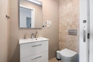 a bathroom with a toilet and a sink and a mirror at Paraná in Quarteira