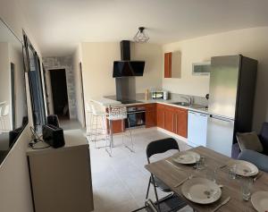 a kitchen with a table and a dining room at Charmant logement avec terrasse et parking sécurisé in Arpajon-sur-Cère