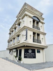 a tall white building with a sign on it at Hotel Casa Inn in Indore