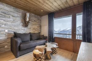 a living room with a couch and a table at Résidence La Forêt Du Praz - Courchevel 1850 in Courchevel
