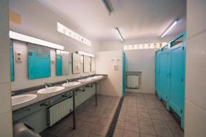 a bathroom with three sinks and blue stalls at Kampaoh Oliva in Oliva +35 photos