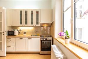 a small kitchen with white cabinets and a window at St. Hubert House in Prague