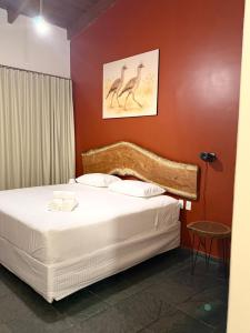 a bedroom with a bed with two birds on the wall at Pousada Casa Cerrado in Colinas Do Sul