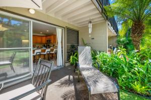 a patio with two chairs and a table on a house at Maui Sands 1B in Honokowai
