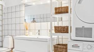 a white bathroom with a sink and a microwave at 10041-1-Rorvig-Langesovej-2 in Rørvig +25 photos