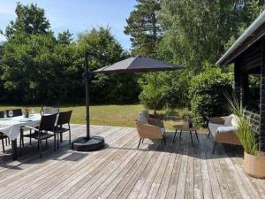 a patio with an umbrella and a table and chairs at 10041-1-Rorvig-Langesovej-2 in Rørvig
