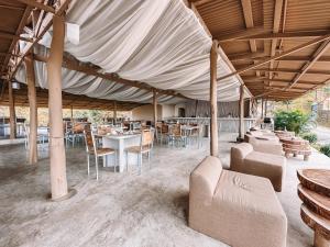 a tent with chairs and tables and a table and chairs at Dar Lamia Boutique Hotel - Adults Only in Manuel Antonio