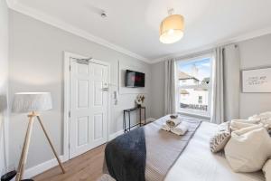 ein weißes Schlafzimmer mit einem Bett und einem Fenster in der Unterkunft Long Stay Ready King Bed Kitchen WiFi Town in Gravesend