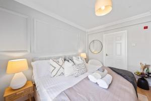 ein Schlafzimmer mit einem Bett mit weißen Laken und Kissen in der Unterkunft Long Stay Ready King Bed Kitchen WiFi Town in Gravesend + 3 Fotos