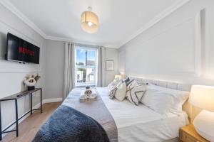 ein Schlafzimmer mit einem großen weißen Bett und einem Fenster in der Unterkunft Long Stay Ready King Bed Kitchen WiFi Town in Gravesend