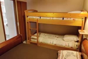 two bunk beds in a room with a table at Appartement cosy à Alfortville - 30 m² - Jardin privé in Alfortville
