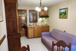 a living room with a purple couch and a kitchen at Appartement cosy à Alfortville - 30 m² - Jardin privé in Alfortville