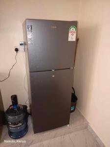 a refrigerator in a room with a wall at Colokhaly Apartment in Nairobi
