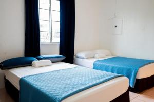 deux lits dans une chambre avec une fenêtre dans l'établissement Tinian Island Haven, Sapphire Unit Apartment, 