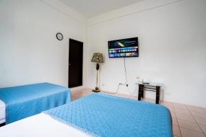 une chambre avec deux lits et une télévision à écran plat dans l'établissement Tinian Island Haven, Sapphire Unit Apartment, 