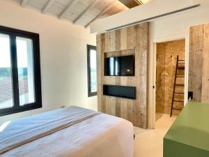 チェチナにあるLuxury Villa San Giuseppe AGRITURISMOのベッドと壁掛けテレビのある寝室 +21枚の写真