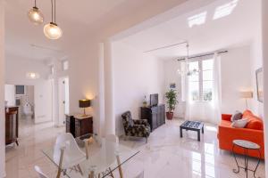 a white living room with a red couch and chairs at Valletta Collection - Grand Harbour Suites 9A in Valletta