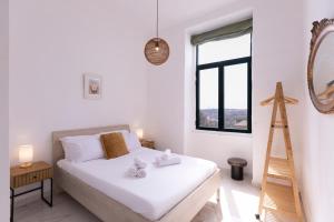 a bedroom with a bed and a ladder and a mirror at Valletta Collection - Grand Harbour Suites 9A in Valletta