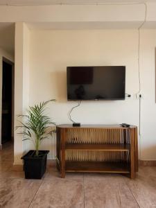 サン・ミゲル・デ・トゥクマンにあるShinny, beautiful, ideally located!の壁にテレビが掛かっているリビングルーム