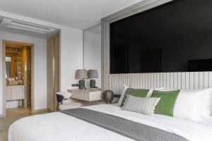 une chambre avec un grand lit blanc avec des oreillers verts dans l'établissement The Ozone Lounge Lovers Golf View Bangtao, à Laguna Phuket 54 autres photos