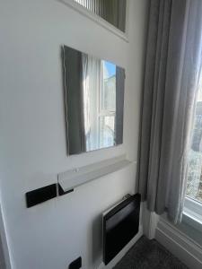 a white bathroom with a mirror and a window at 35 mins London Bridge & Gatwick Airport in Norwood