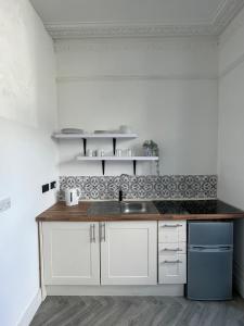 a kitchen with a sink and a counter top at 35 mins London Bridge & Gatwick Airport in Norwood +7 photos