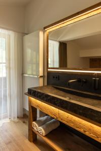 Un baño con un gran espejo y un lavabo. en Das Denisl, en Reit im Winkl 157 fotos más