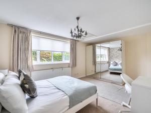 a bedroom with a large bed and a mirror at Pass the Keys Spacious family home in Surrey in Addlestone